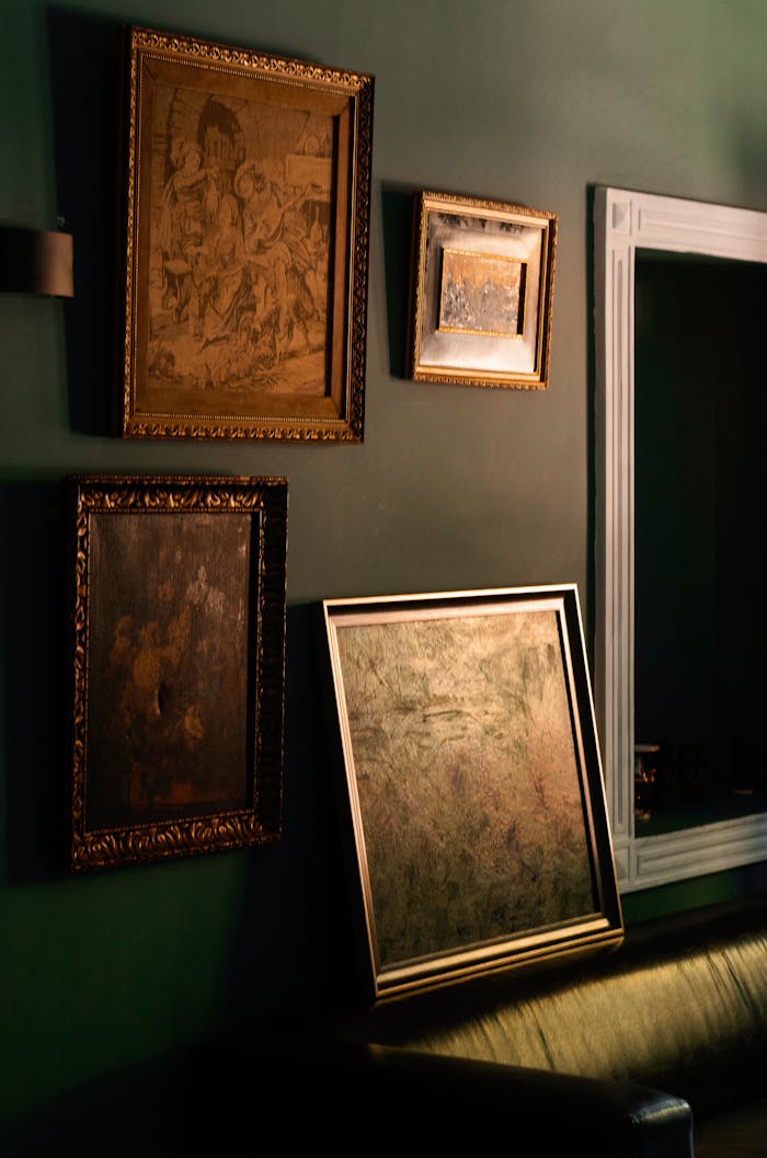 Aesthetic arrangement of vintage art frames on a dimly lit wall, evoking retro vibes.